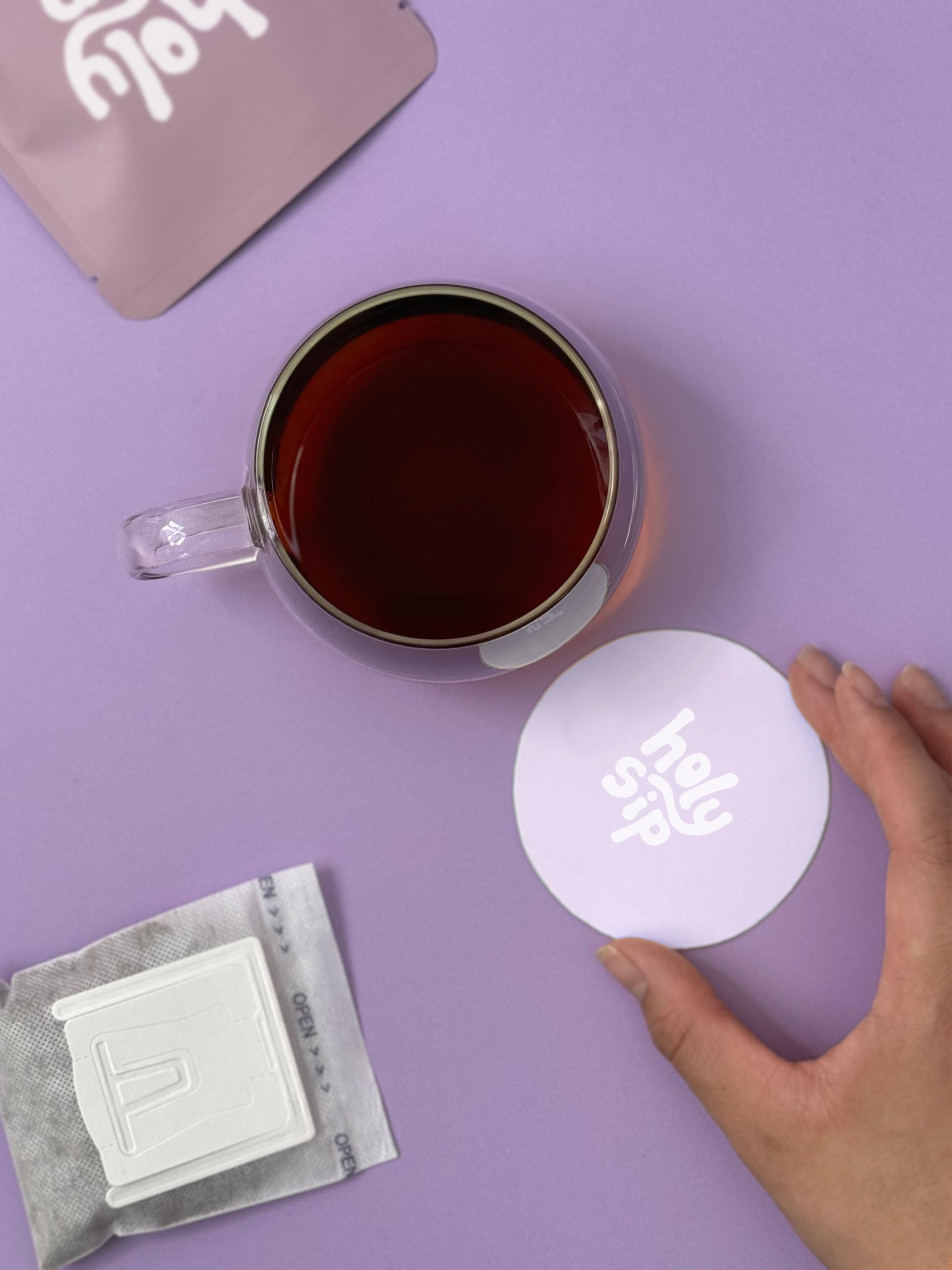 Product photo of holy sip drip coffee bag with coaster and cup of coffee